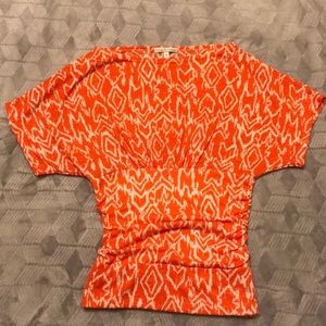 Orange and white fitted waist top.